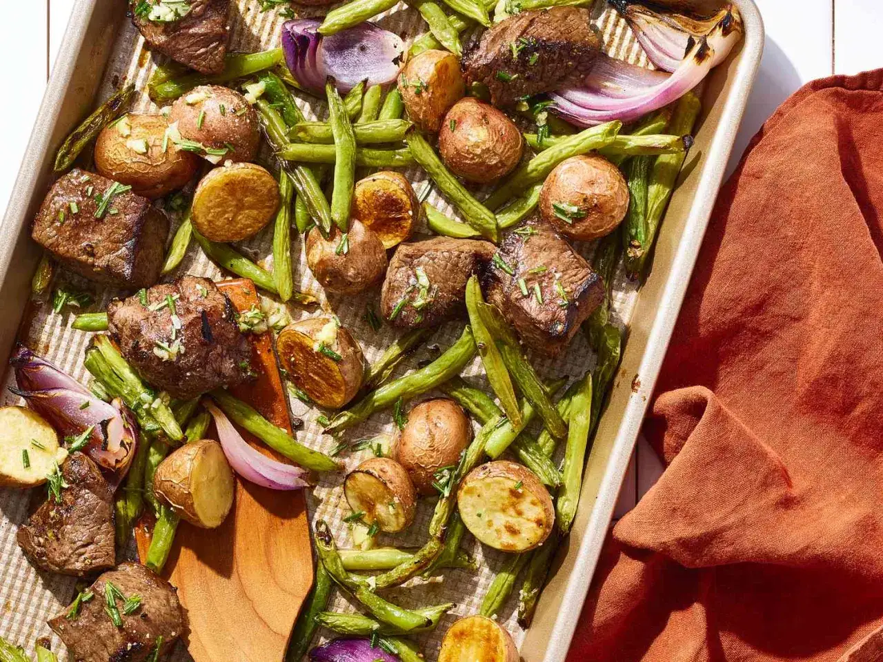 Saftige Rinderw&uuml;rfel mit Rosmarinkartoffeln und gr&uuml;nen Bohnen auf einem Blech &ndash; ein ideales Rezept f&uuml;r schnelle Fleischgerichte.