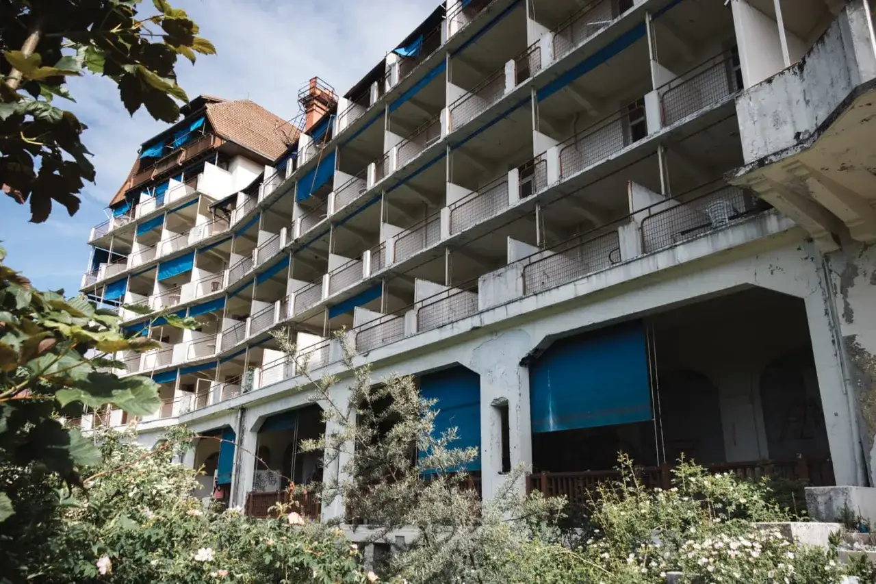 Un h&ocirc;tel abandonn&eacute;, vestige d'une &eacute;poque r&eacute;volue, invite &agrave; l'urbex flippant. Les balcons vides et la v&eacute;g&eacute;tation envahissante racontent une histoire silencieuse.