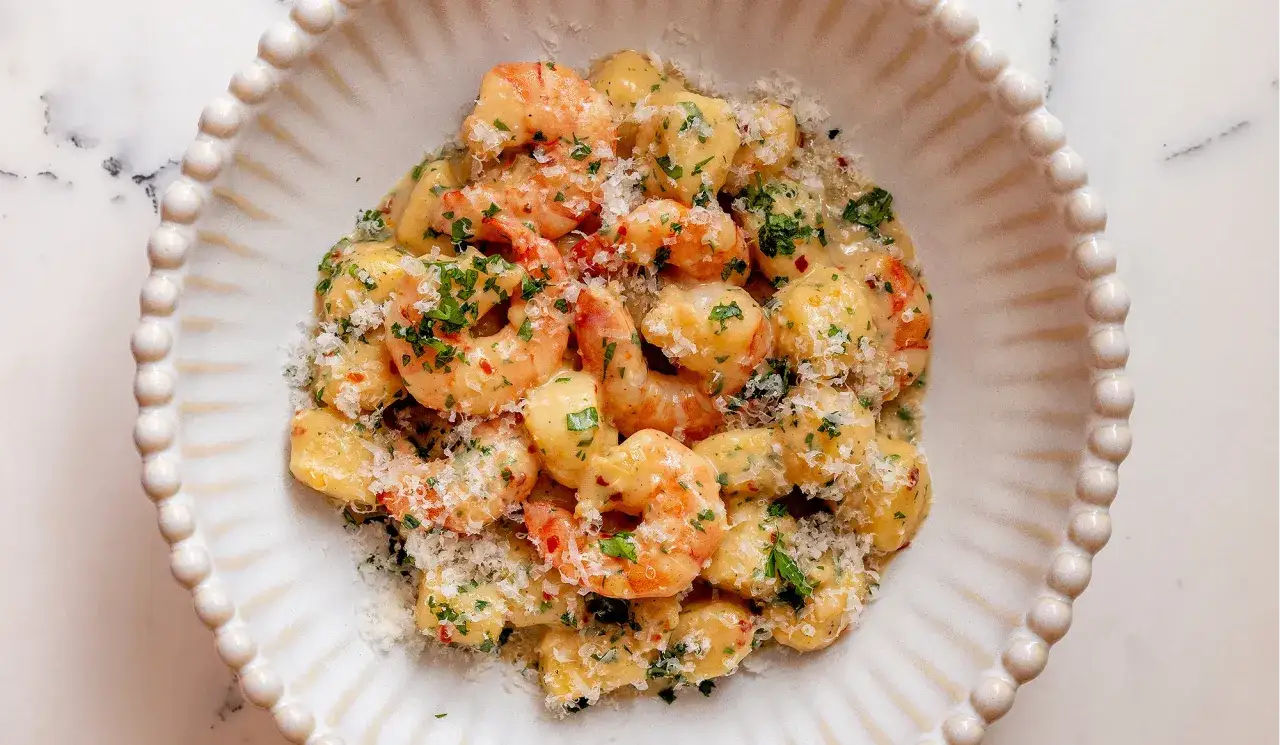 Cremige Gnocchi mit Garnelen, garniert mit frischer Petersilie und Parmesan. Ein köstliches Gericht, das Lust auf mehr macht.