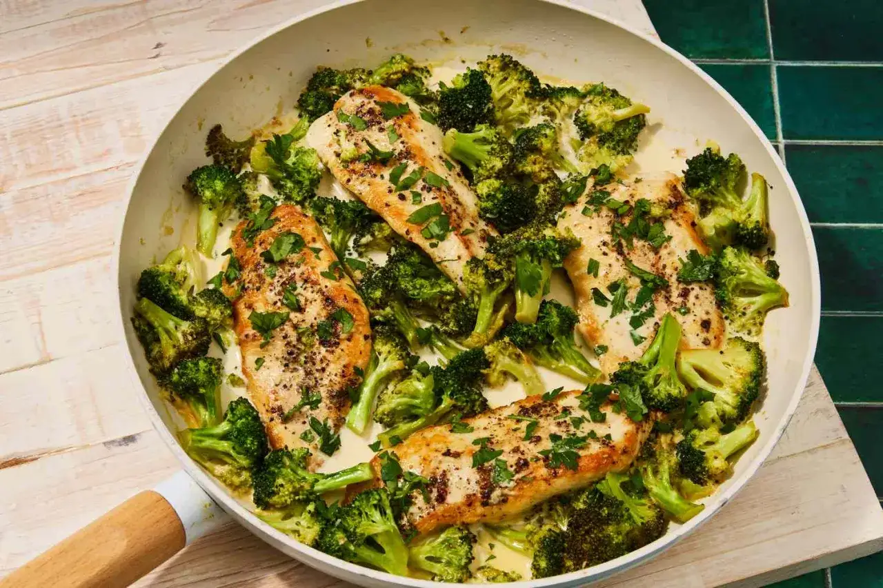 Kurczak z brokułami w kremowym sosie, idealny na dietę low carb. Danie posypane świeżą natką pietruszki.