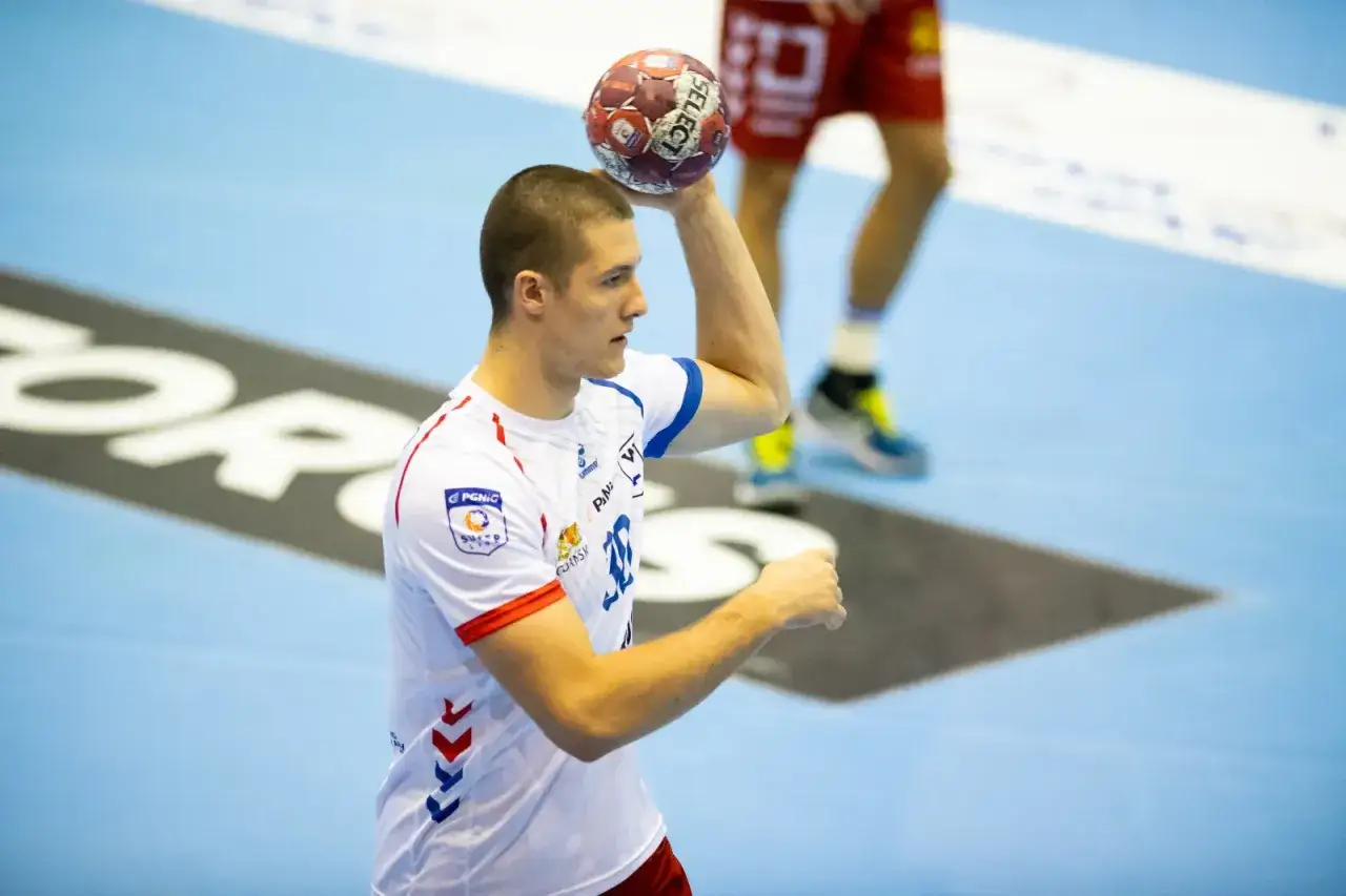 Wiktor Tomczak, szczypiornista, szykuje się do rzutu. Piłka w dłoni, skupienie na twarzy.
