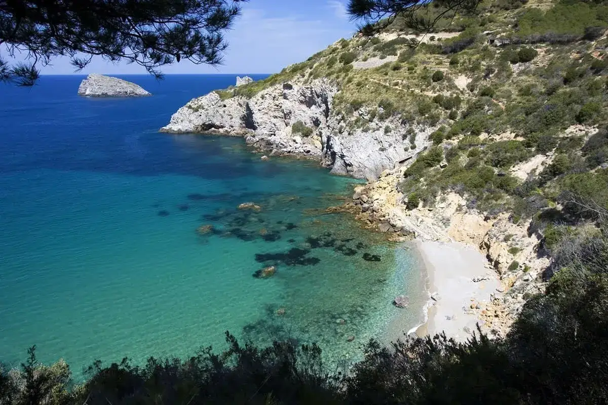 La **cala del gesso Monte Argentario** offre un mare cristallino e una piccola spiaggia incastonata tra scogliere rocciose e macchia mediterranea.