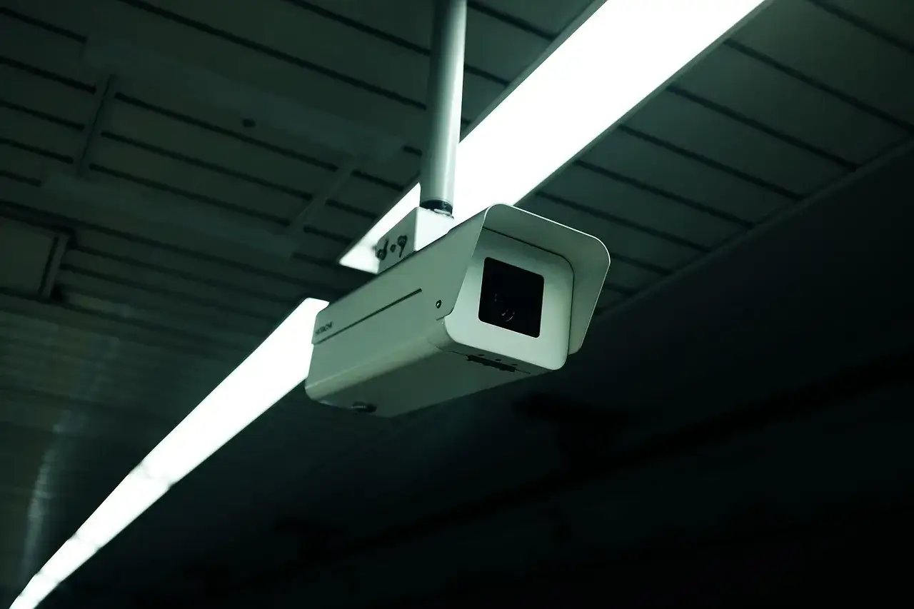 Cámara de seguridad Hitachi colgada del techo, vigilando quién puede ver las imágenes.
