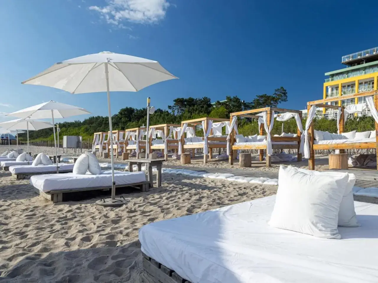 Luksusowe hotele nad morzem z basenem oferują plażowe łóżka z baldachimami i białymi poduszkami. Idealne miejsce na relaks.