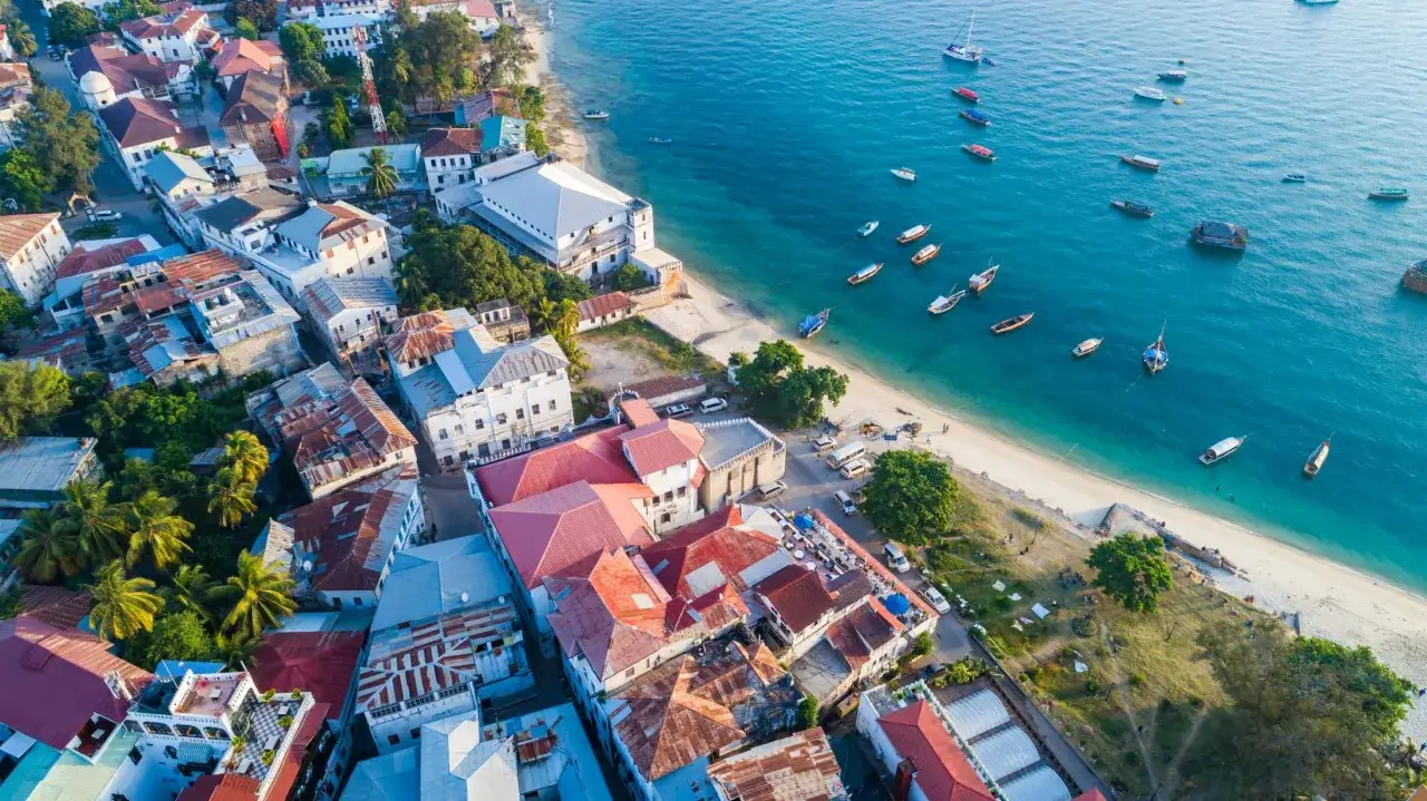 Widok z lotu ptaka na Stone Town na Zanzibarze, z łodziami na turkusowym morzu. Zastanawiasz się, ile kosztuje wycieczka na Zanzibar?