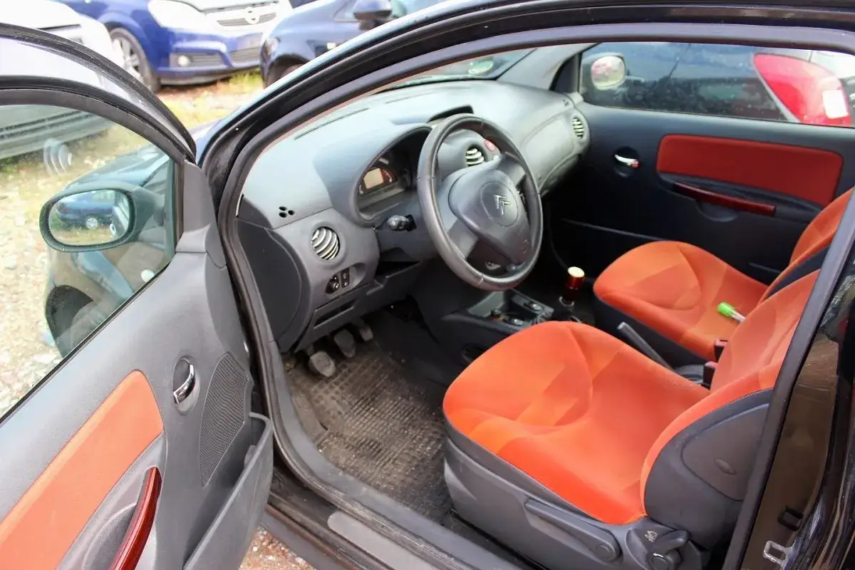 Wnętrze Citroen C2 VTR z pomarańczowymi siedzeniami i czarną deską rozdzielczą.