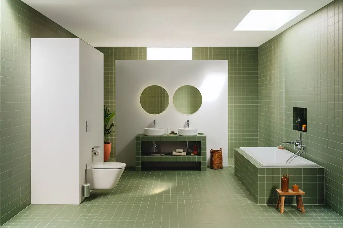 Modernos baños reformados con azulejos verdes, doble lavabo, bañera y WC suspendido. Un oasis de tranquilidad.