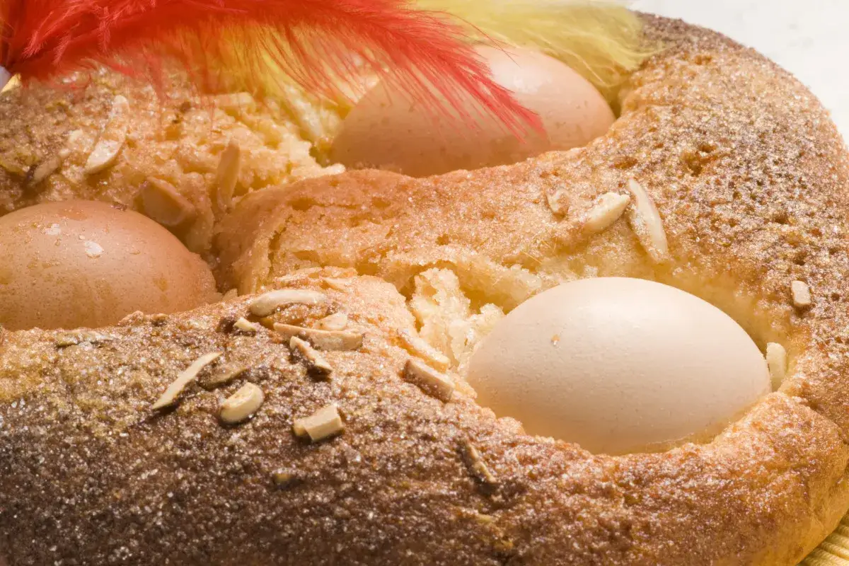 Monas de Pascua con huevos cocidos, almendras y plumas rojas y amarillas. ¡Un dulce tradicional!