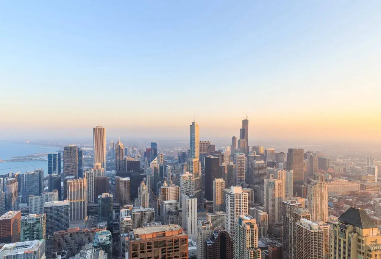 Widok na panoramę Chicago o zachodzie słońca. Zastanawiasz się, ile kosztuje lot do Stanów Zjednoczonych?