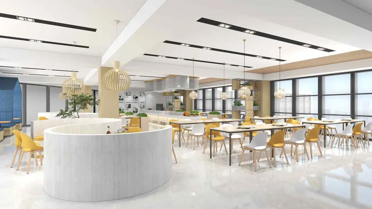 Une salle de pause originale avec des cloisons courbes, des tables jaunes et blanches, et des luminaires en bois.