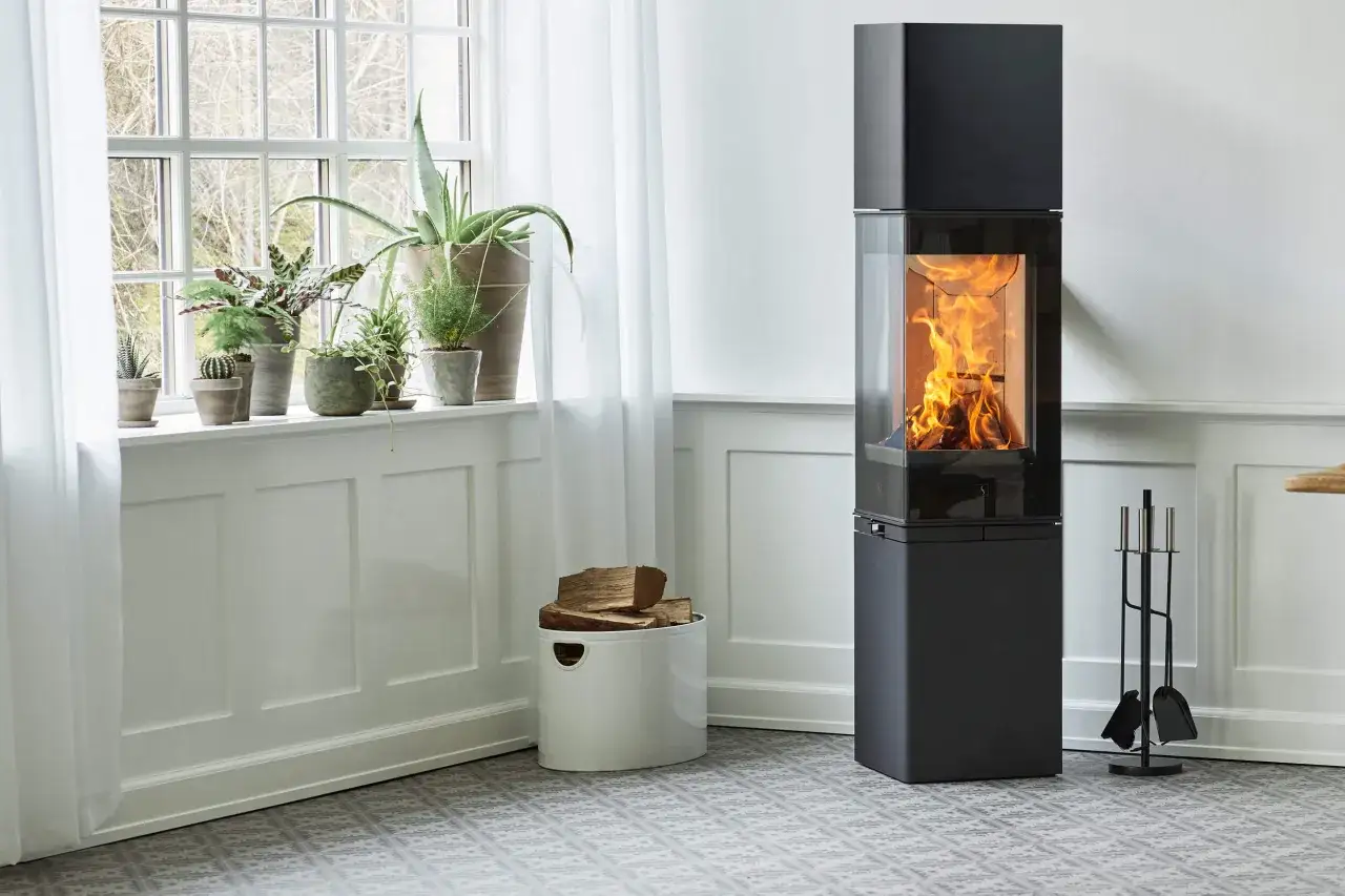 En modern kamin med flammande ved ger en mysig v&auml;rme. Fr&aring;gan &auml;r hur varmt det blir i en kamin n&auml;r den eldas.