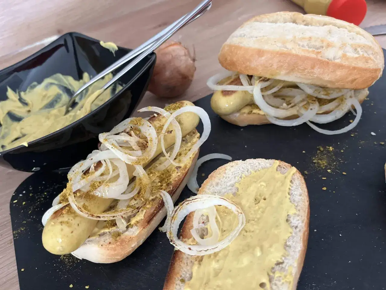 Zwei Würstchen im Brötchen mit Zwiebeln und Senf, ein klassisches Bosna Rezept für den schnellen Genuss.
