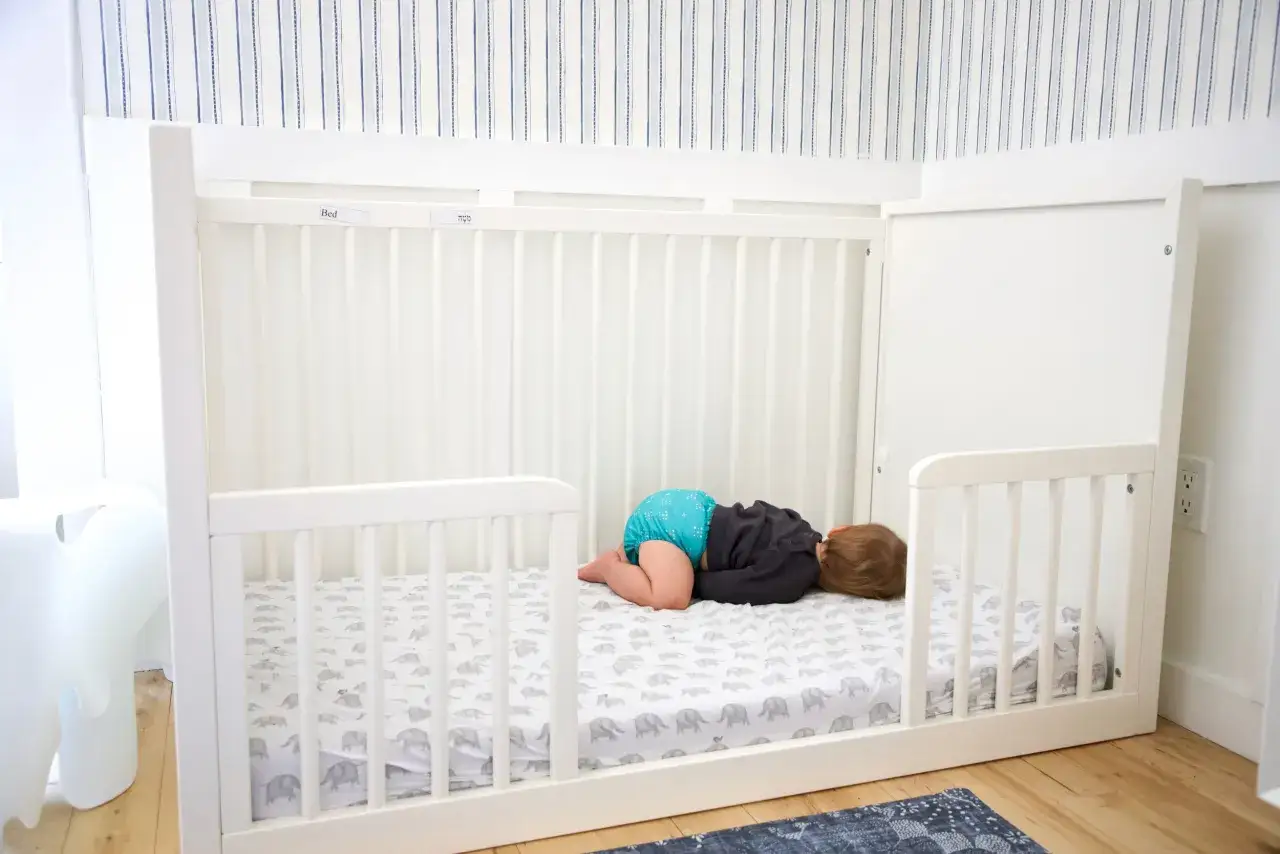 A baby sleeps on a floor bed, a safe option for little ones exploring their independence.