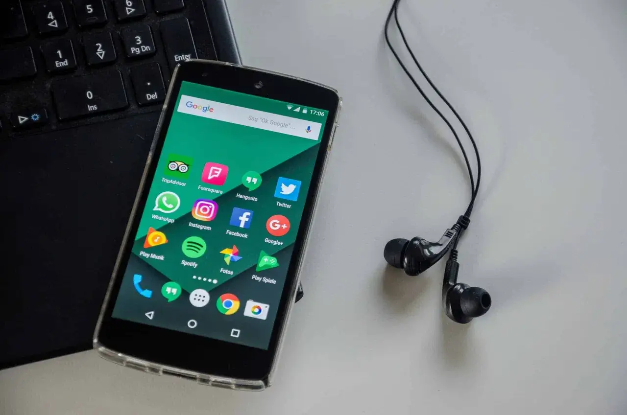 Telefon z aplikacjami, słuchawki i klawiatura. Idealny zestaw do słuchania muzyki na telefon za darmo.