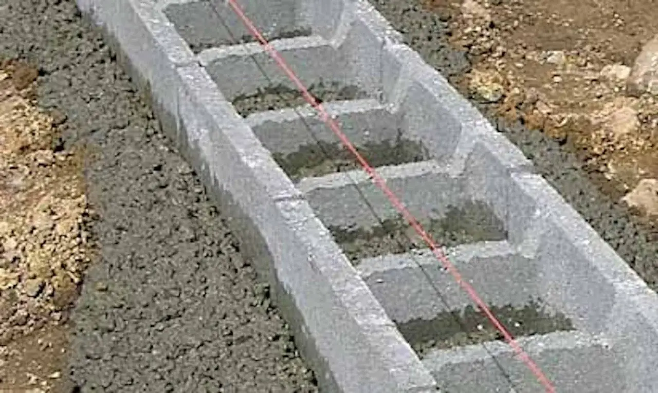 Grundläggning för gjuta platta garage. Betongblock och grus förbereds för gjutning.
