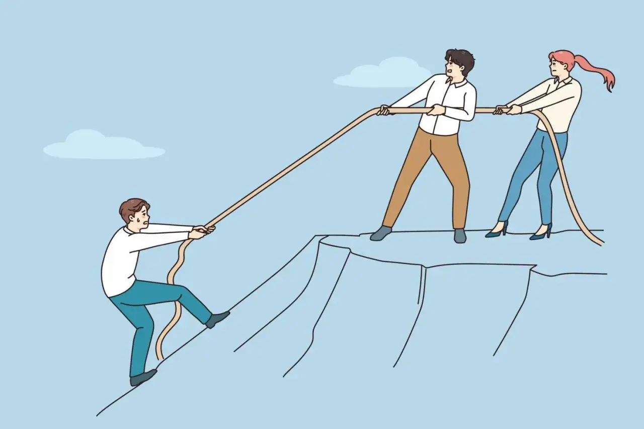 Three people play tug-of-war on a cliff. One person climbs up, while two pull down. This illustrates what is OCB: a struggle for control.