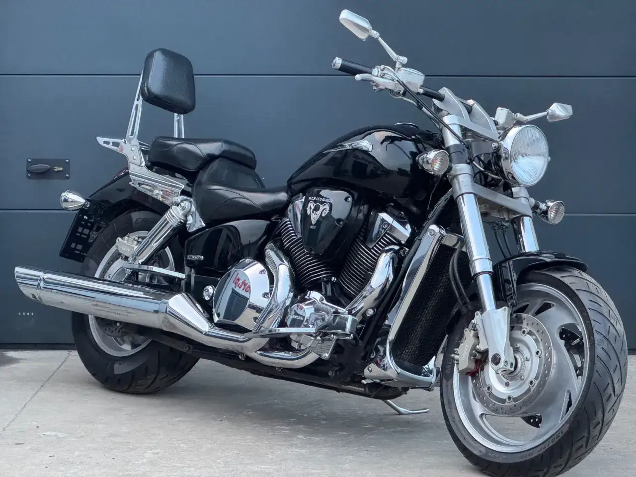 Czarny motocykl Honda VTX 1800, z chromowanymi elementami i wygodnym siedzeniem. Wady i zalety tego potężnego cruisera są widoczne w jego masywnej budowie i mocnym silniku.