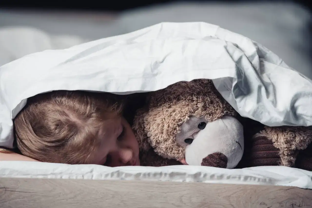 Ett barn sover s&ouml;tt med nallen under t&auml;cket. Det &auml;r vanligt att en 3-&aring;ring kissar p&aring; sig p&aring; natten.