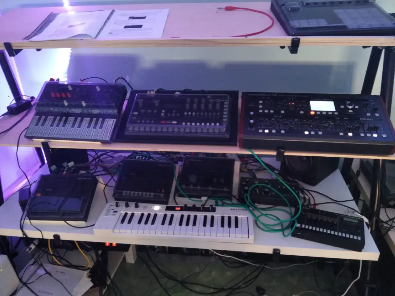 Synthesizer-Setup mit mehreren Geräten, darunter ein Arturia-Keyboard und ein elektronisches Instrument, das für elektronische Klänge konzipiert ist.