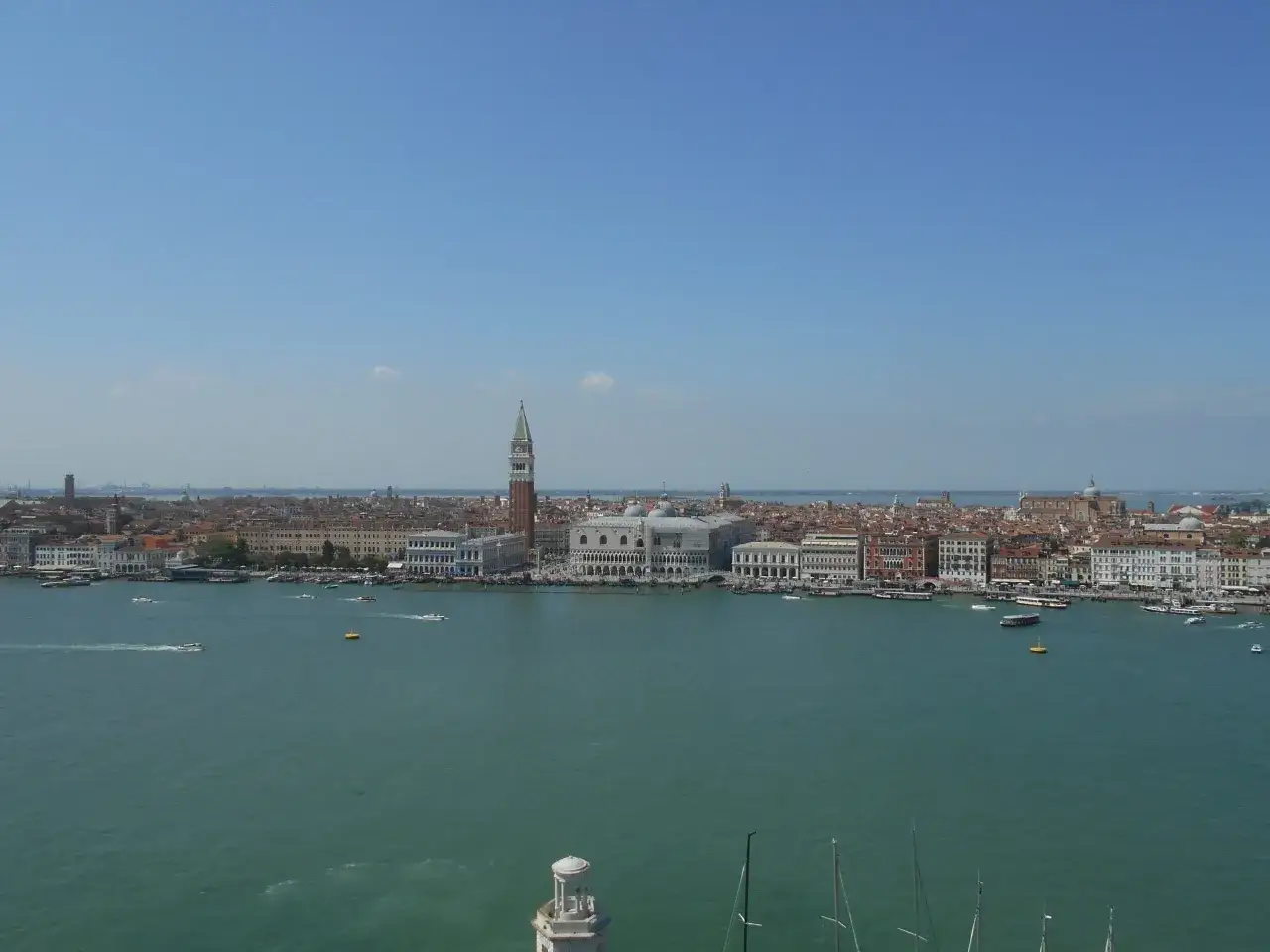 Venezia dall'alto: il Canal Grande con gondole e vaporetti, sullo sfondo il Palazzo Ducale e il Campanile di San Marco.