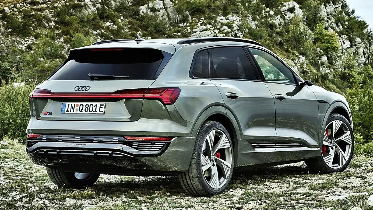 Zielony Audi Q8 e-tron na tle górskiego krajobrazu. Sprawdź aktualną audi q8 cena i możliwości tego elektrycznego SUV-a.