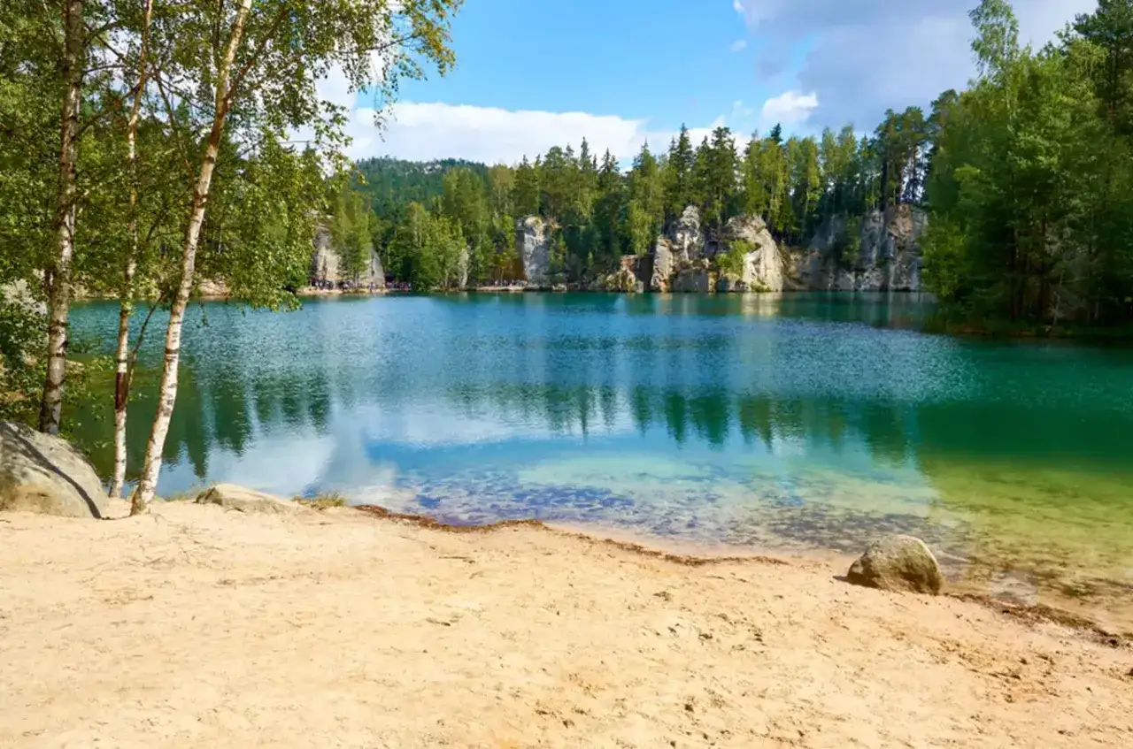 Piękne, turkusowe jezioro otoczone skalnymi formacjami i lasem. Widok na Góry Adrspach zapiera dech w piersiach.