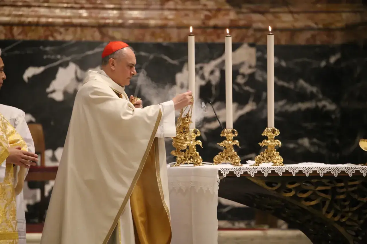 Ein Kardinal in roter Kopfbedeckung und weißem Gewand mit goldenen Verzierungen hält ein goldenes Räuchergefäß. Rauch steigt auf, während er sich Kerzen und einem Altar nähert. Der Weg, wie wird man Kardinal, ist lang und voller Hingabe.