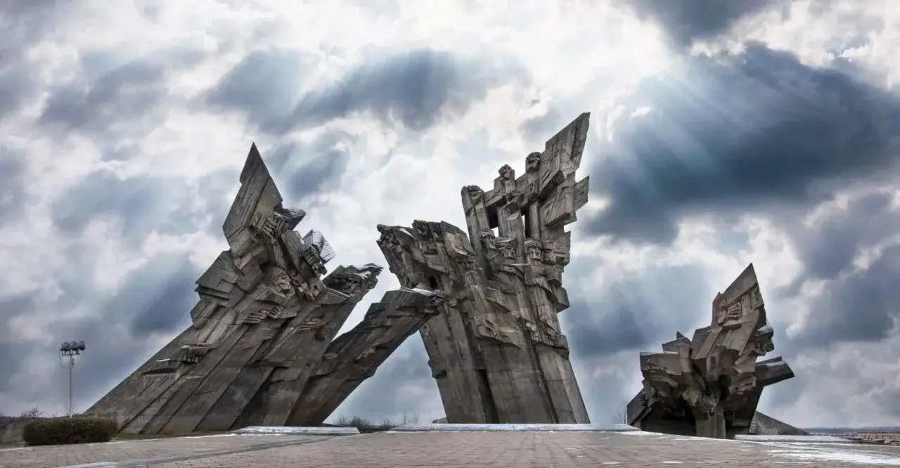 Monumentalne rzeźby z betonu, imponujące kowno atrakcje pod burzliwym niebem.