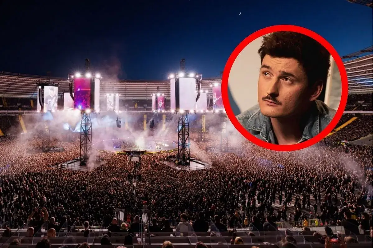 Gwiazda z wąsem w czerwonym okręgu na tle największego koncertu w Polsce. Tysiące fanów na stadionie, światła i dym.