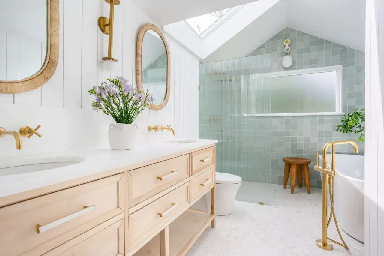 Ein helles Badezimmer mit Doppelwaschtisch, Spiegeln, Dusche und Badewanne. Hier sieht man, was man im Badezimmer braucht: Waschtisch, Spiegel, Toilette, Dusche, Badewanne.