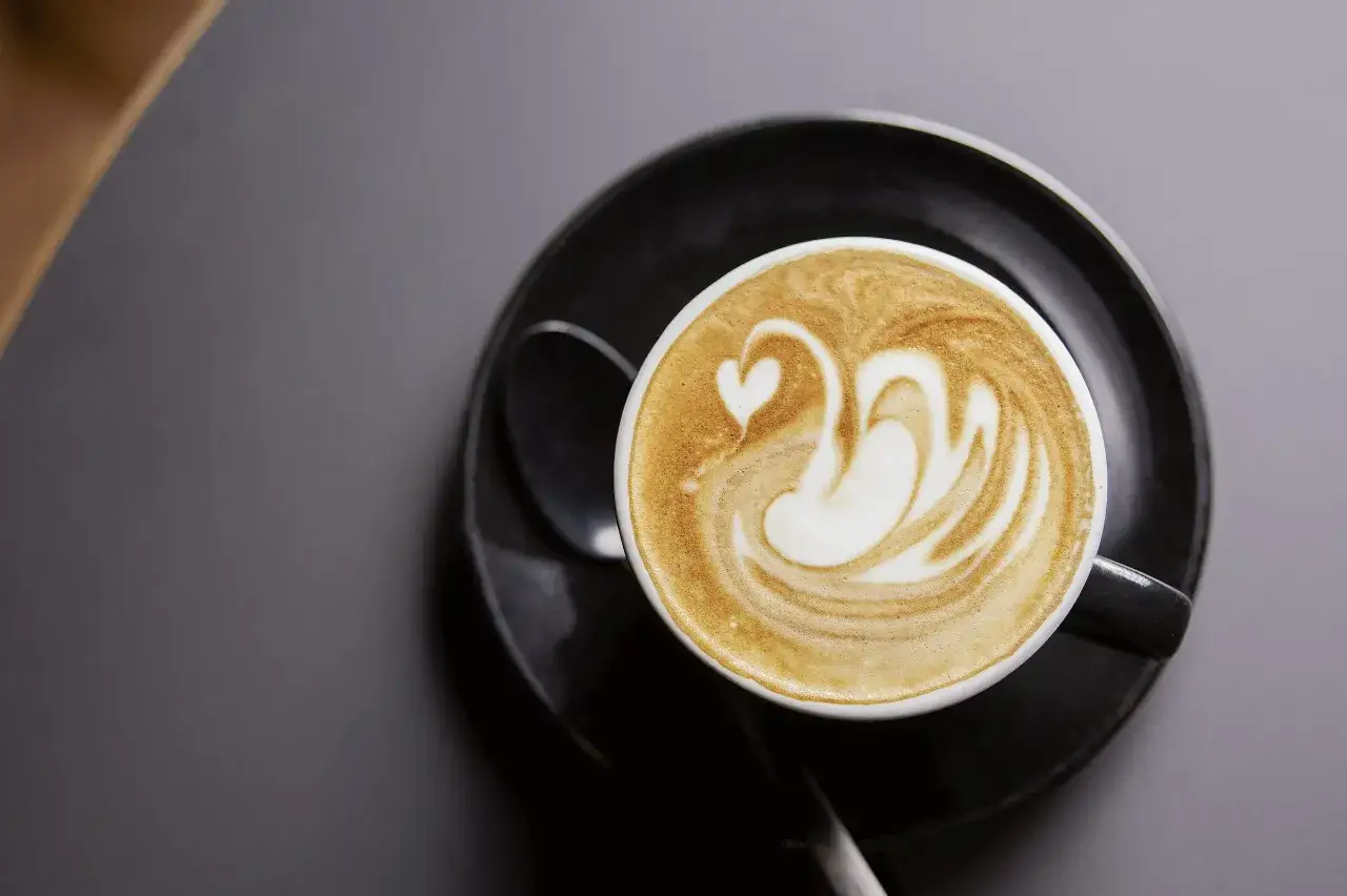 Ein Latte Macchiato mit einem Schwan aus Milchschaum. Was ist Kaffee Latte? Ein Genuss für die Sinne, perfekt für den Morgen.