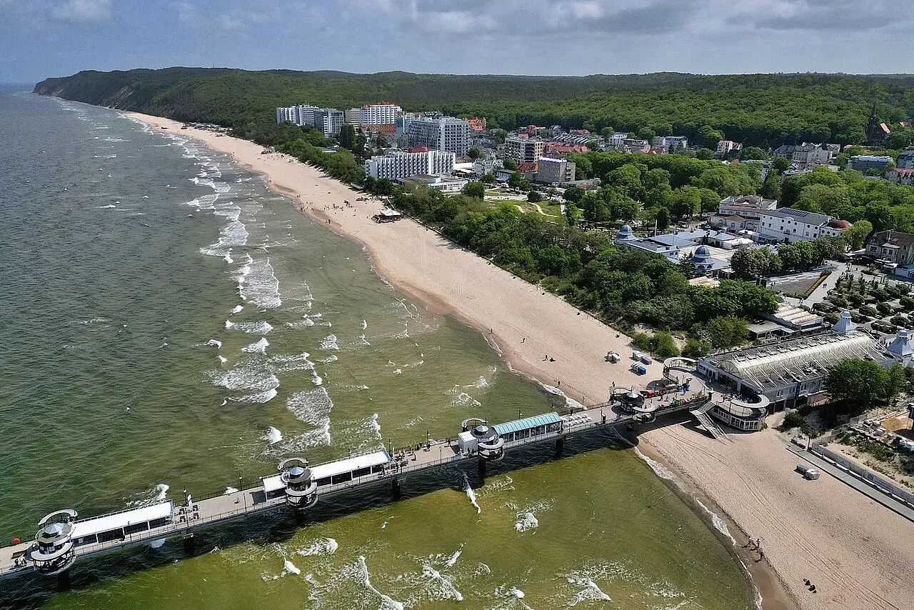 Miejscowości Pomorza Zachodniego: plaża, molo i zabudowania kurortowe nad Bałtykiem.