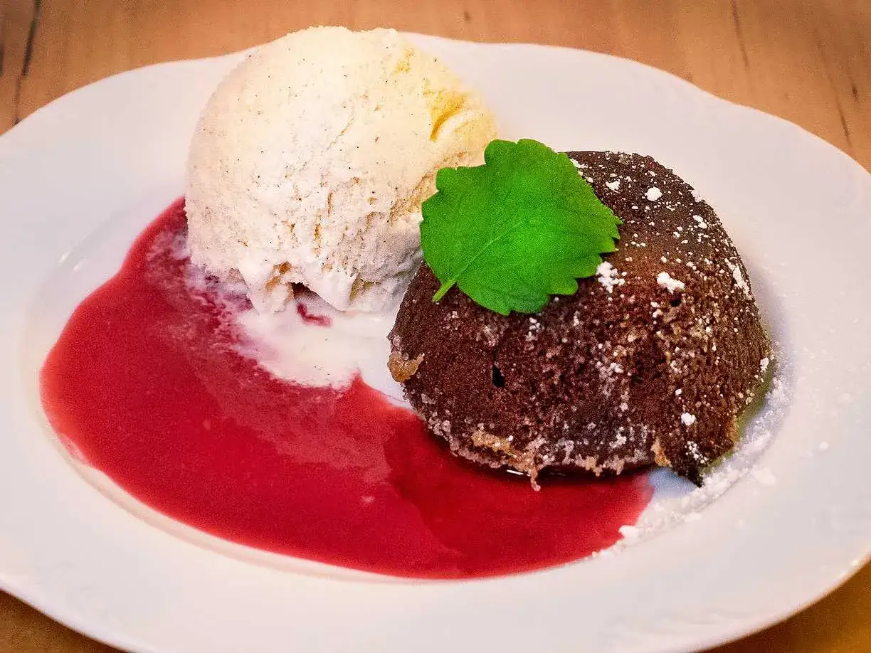 En läcker choklad fondant med vaniljglass, hallonsås och en myntakvist.