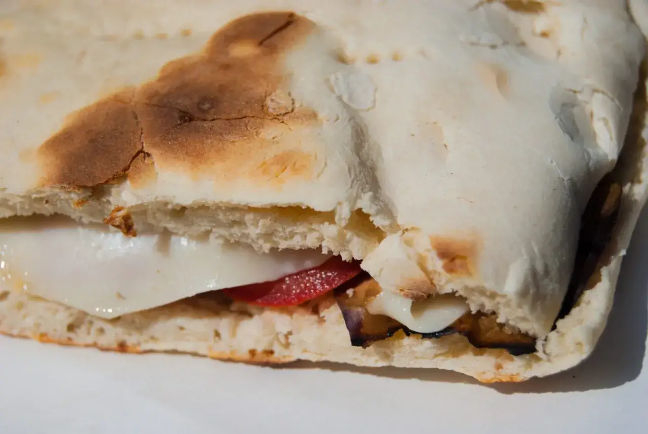 Crescia umbra ripiena di formaggio filante, pomodoro e melanzane grigliate. Un morso di gusto!