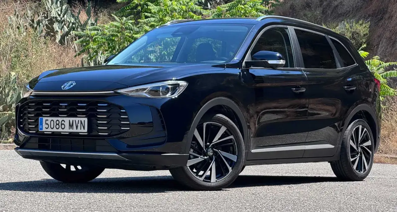 MG ZS en prueba, un SUV negro moderno aparcado al aire libre con vegetaci&oacute;n de fondo.