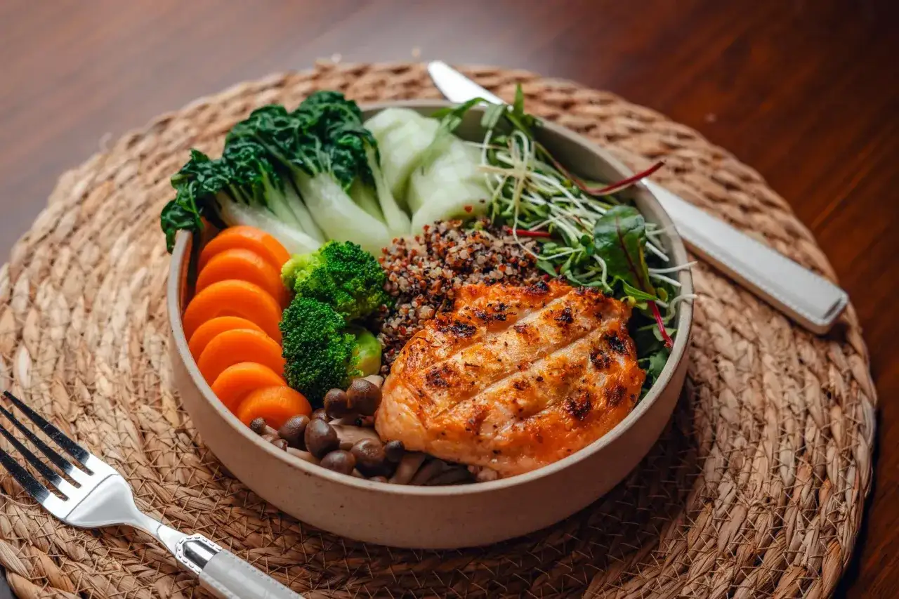 Gesunder Lachs-Bowl mit Quinoa, Gemüse und Pilzen. Perfekt, um zu wissen, was essen bei Periode.