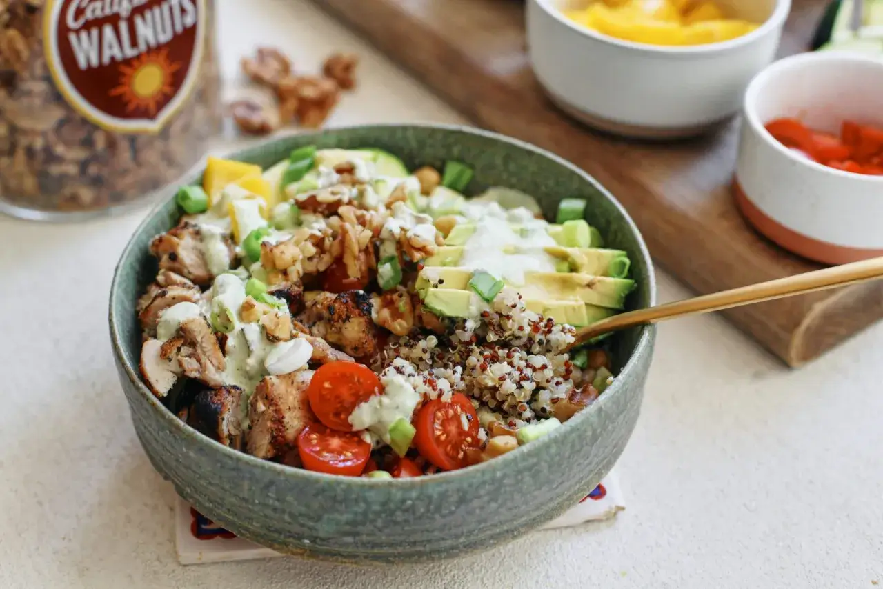 Bowl con pollo, quinoa, aguacate, tomates y nueces. Una opci&oacute;n saludable de alimentos quema grasa por la noche.
