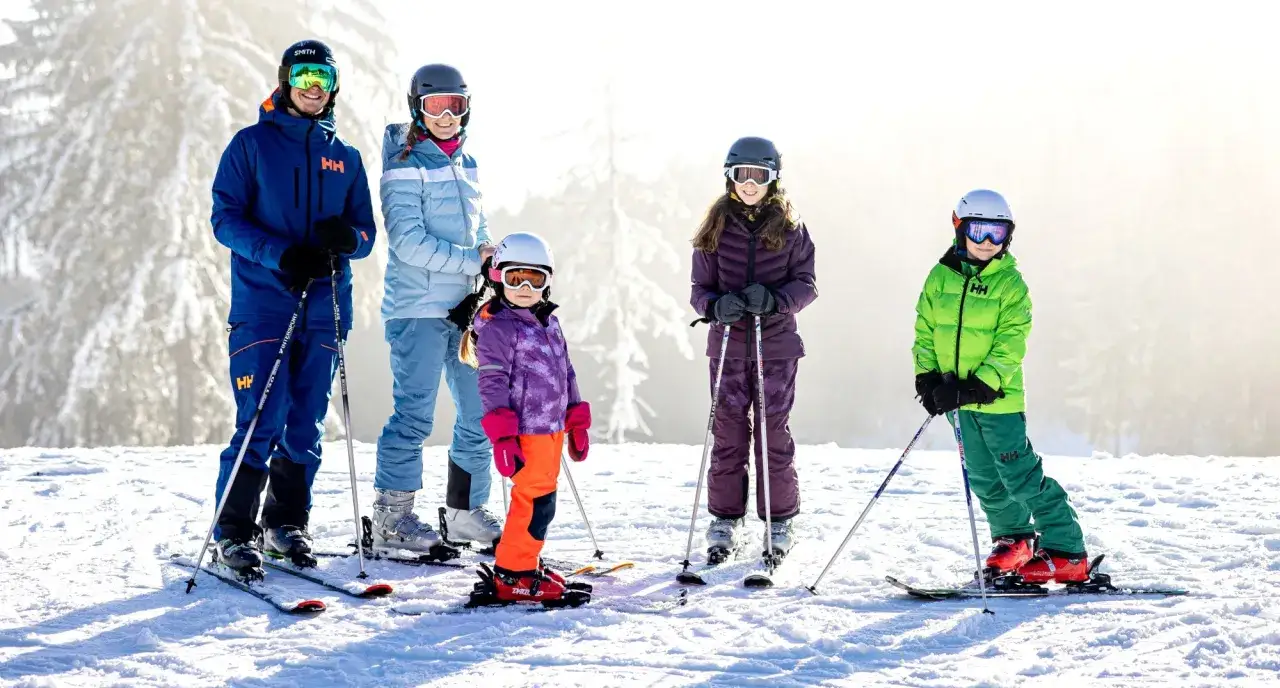 Familie im Lipno Skigebiet, bereit f&uuml;r den Pistenspa&szlig;. Sonnenschein und frische Luft machen den Tag perfekt.