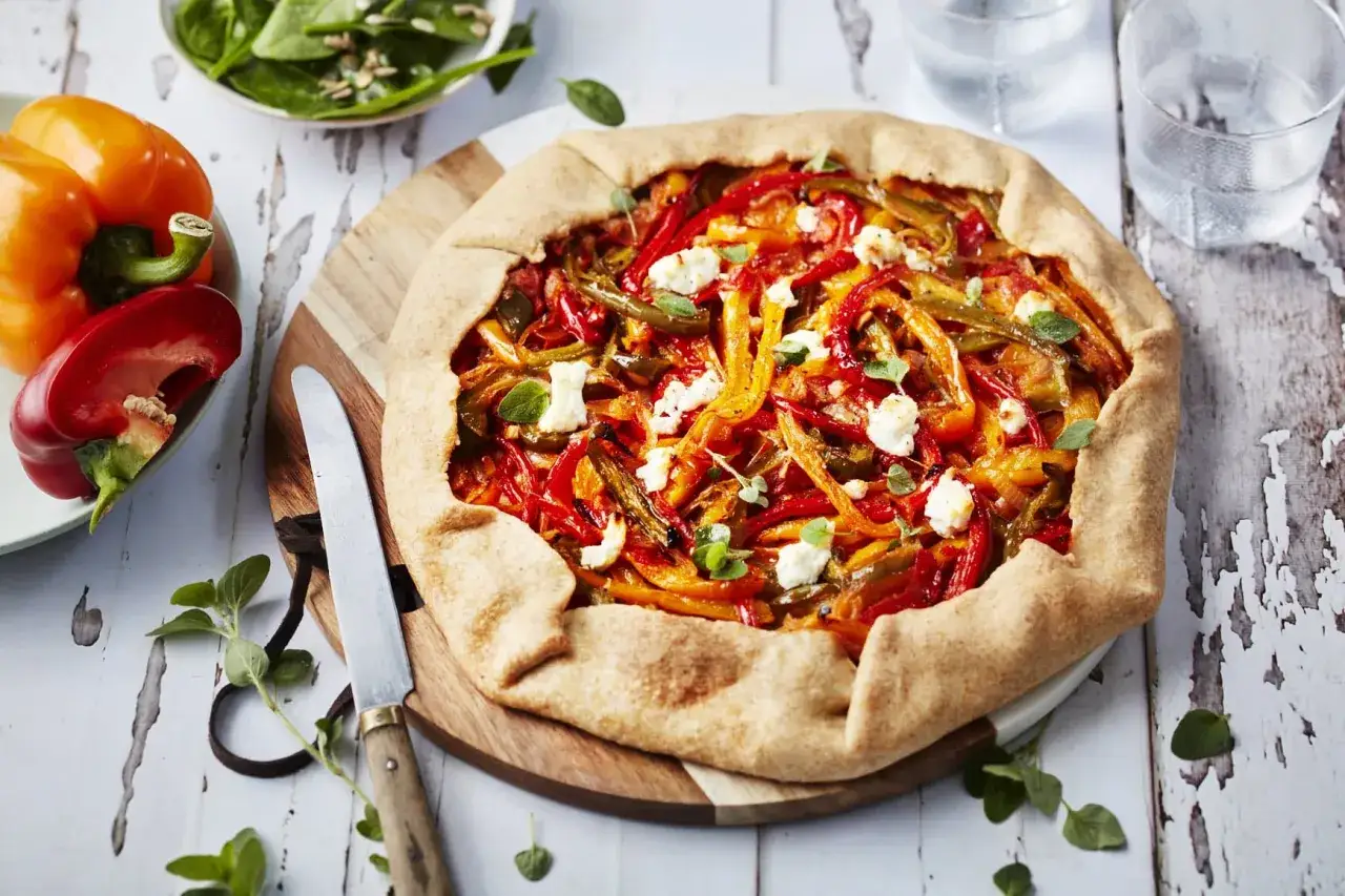 Une galette rustique garnie de poivrons color&eacute;s et de feta &eacute;miett&eacute;e, pr&ecirc;te &agrave; &ecirc;tre d&eacute;gust&eacute;e.