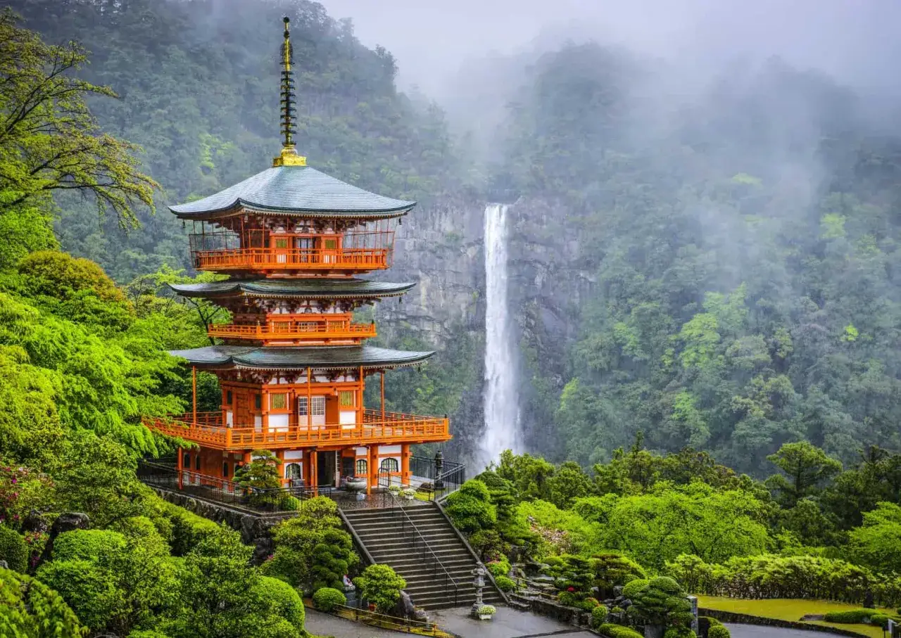 Pomarańczowa pagoda i wodospad w otoczeniu bujnej zieleni – to widok, z czego słynie Japonia.
