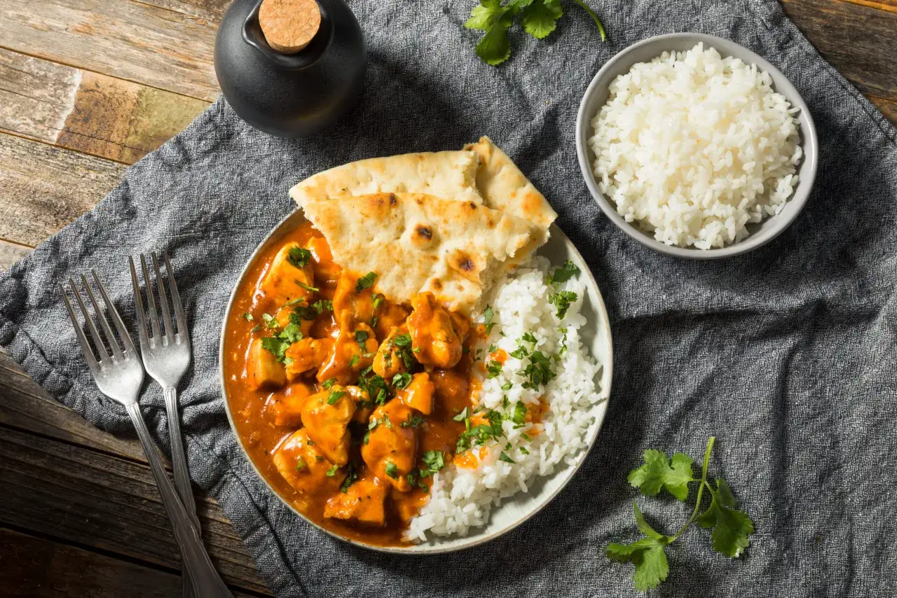 Pyszny Butter Chicken przepis: kremowy kurczak w sosie pomidorowym z ryżem i chlebkiem naan. Idealny obiad.