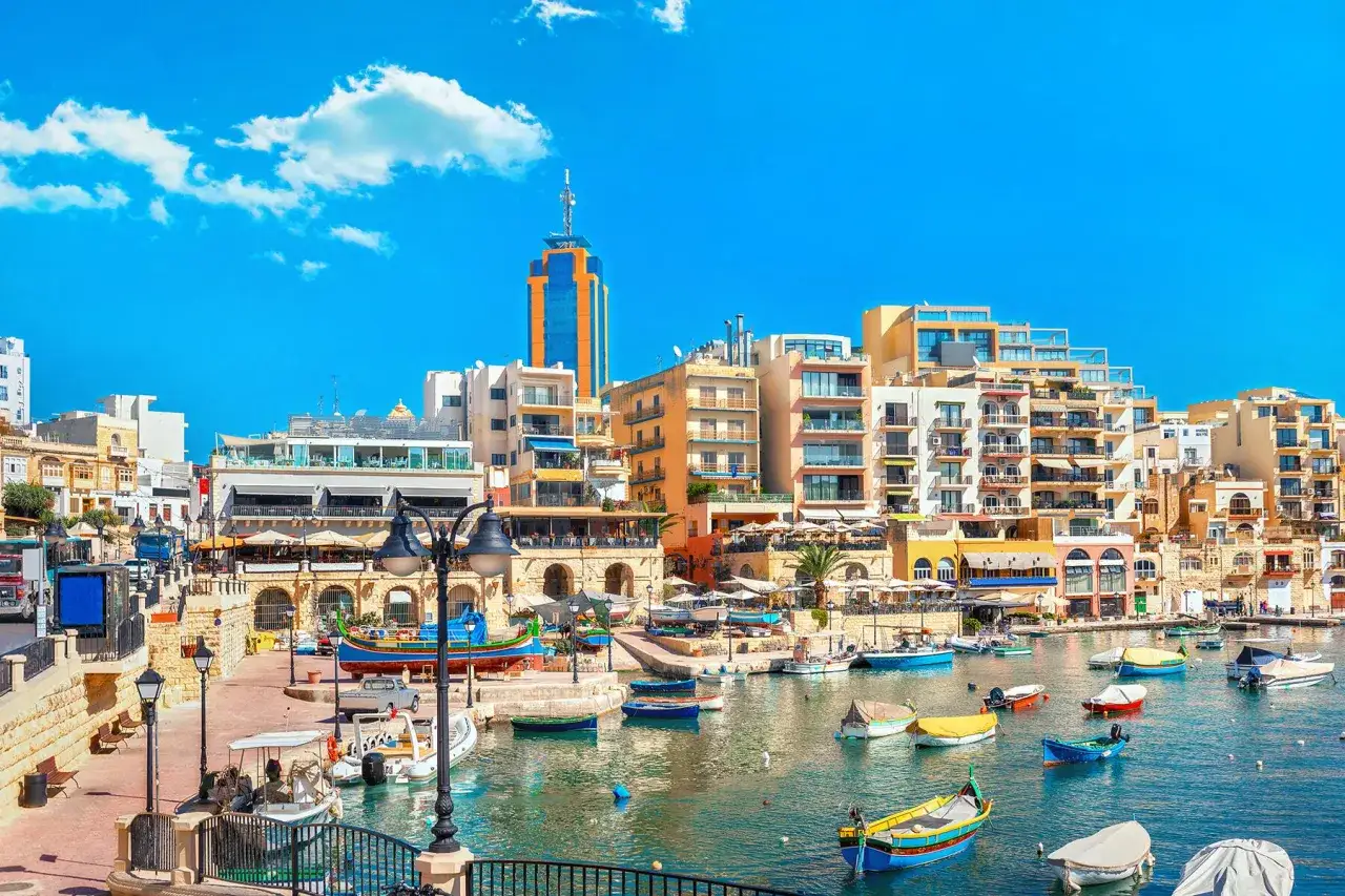 Malta czy warto? Słoneczny port z kolorowymi łodziami i malowniczymi kamienicami. Idealne miejsce na wakacje.