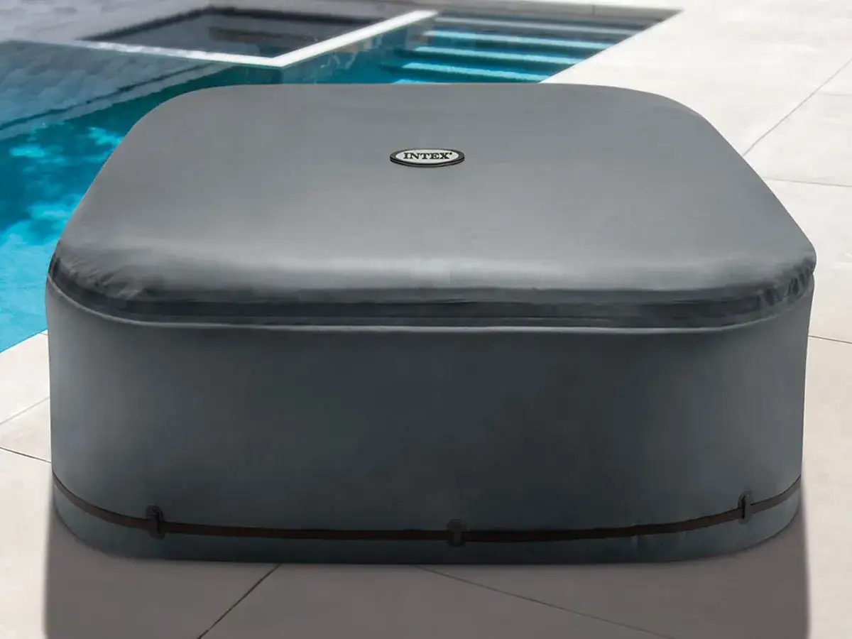 Un spa gonflable Intex couvert, prêt pour l'hiver ou pour garder l'eau propre. L'isolation est assurée par sa housse grise.