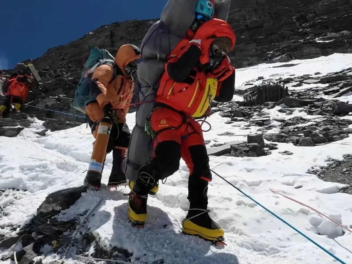 Bergsteiger k&auml;mpfen sich auf dem Mount Everest durch Schnee und Eis. Ein Bergsteiger tr&auml;gt eine Sauerstoffflasche, die f&uuml;r die Expedition unerl&auml;sslich ist.