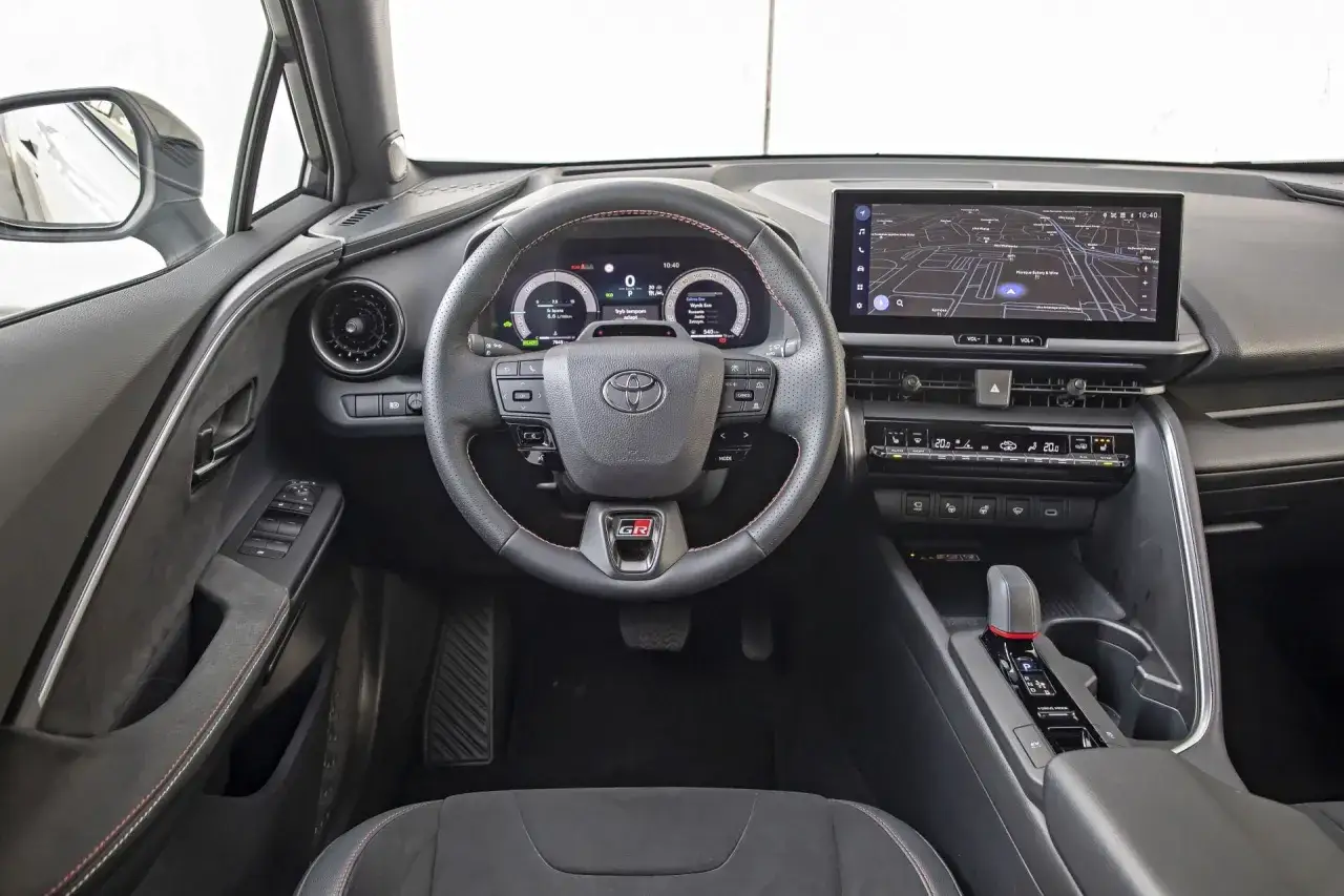 Wnętrze Toyoty GR, nowoczesny kokpit z ekranem nawigacji i cyfrowymi zegarami. Sprawdź atrakcyjną toyota chr cena!