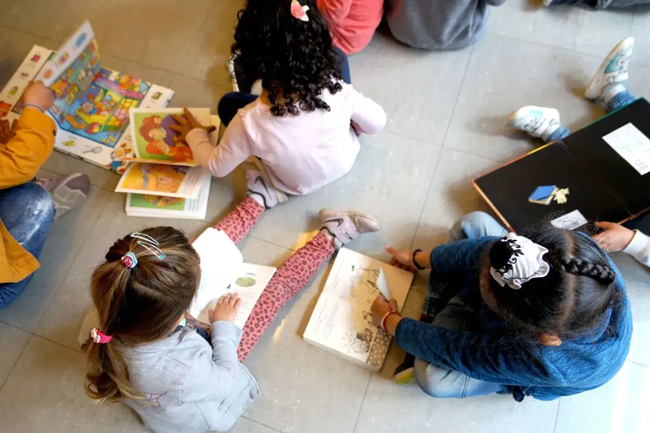 Niños aprendiendo en guardería Comunidad Valenciana. Lectura y diversión en grupo.