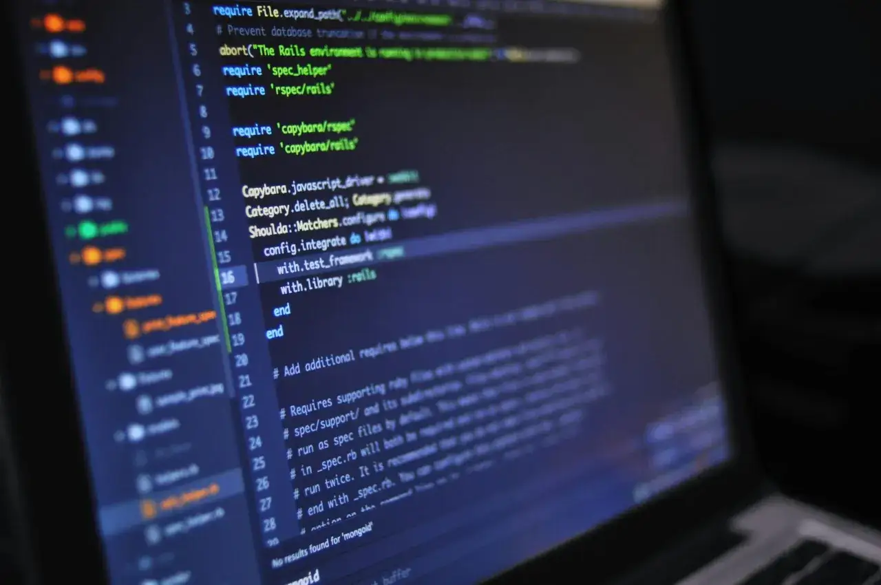 Kod programu na ekranie komputera. Widać fragmenty kodu w języku Ruby, w tym wymagania dla bibliotek takich jak Capybara, używane do testowania aplikacji webowych. To typowy widok dla programisty pracującego nad projektem, gdzie komputer po francusku (...