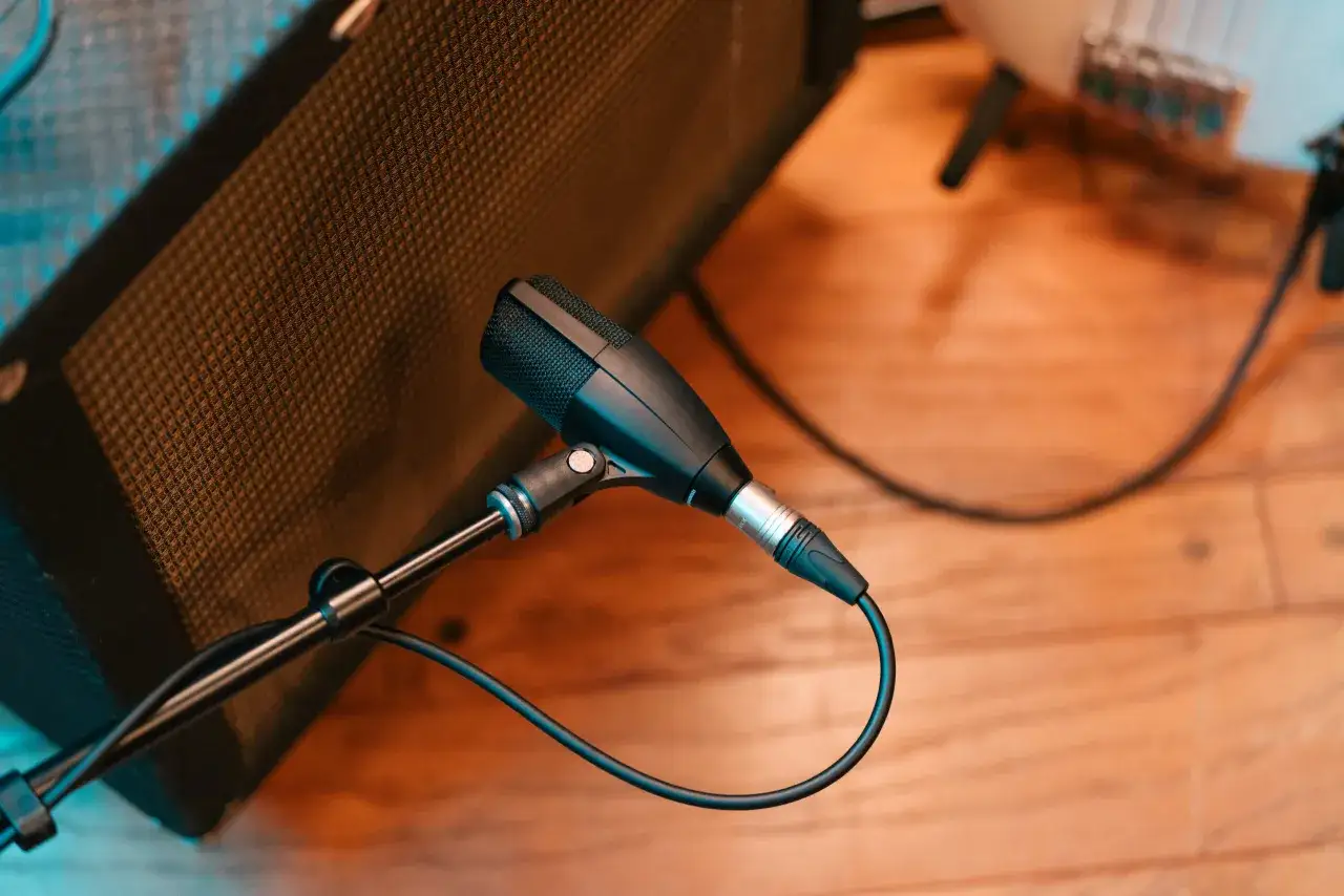 Mikrofon Sennheiser 421 skierowany na głośnik gitarowy, gotowy do nagrania.