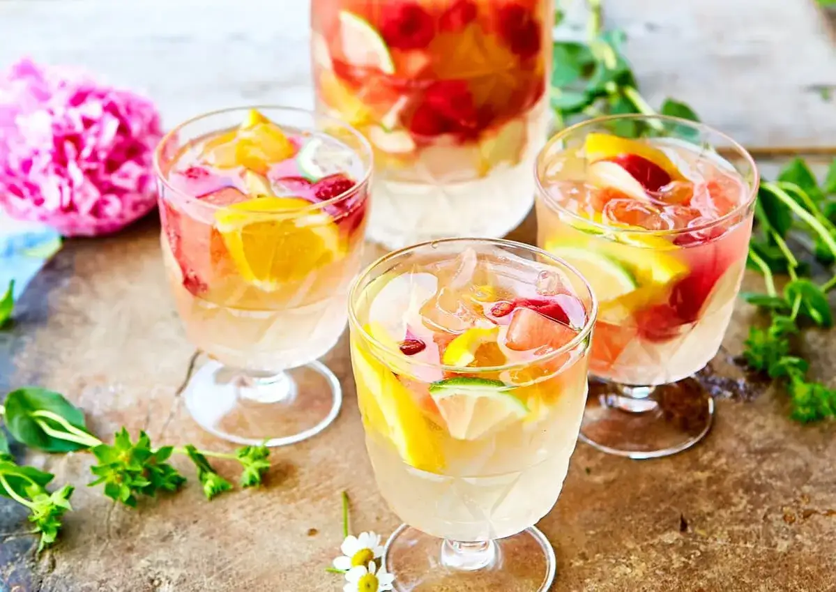 F&auml;rgglad vit sangria med frukt som apelsin, lime och hallon. Perfekt f&ouml;r en sommardag, h&auml;r &auml;r ett enkelt vit sangria recept.