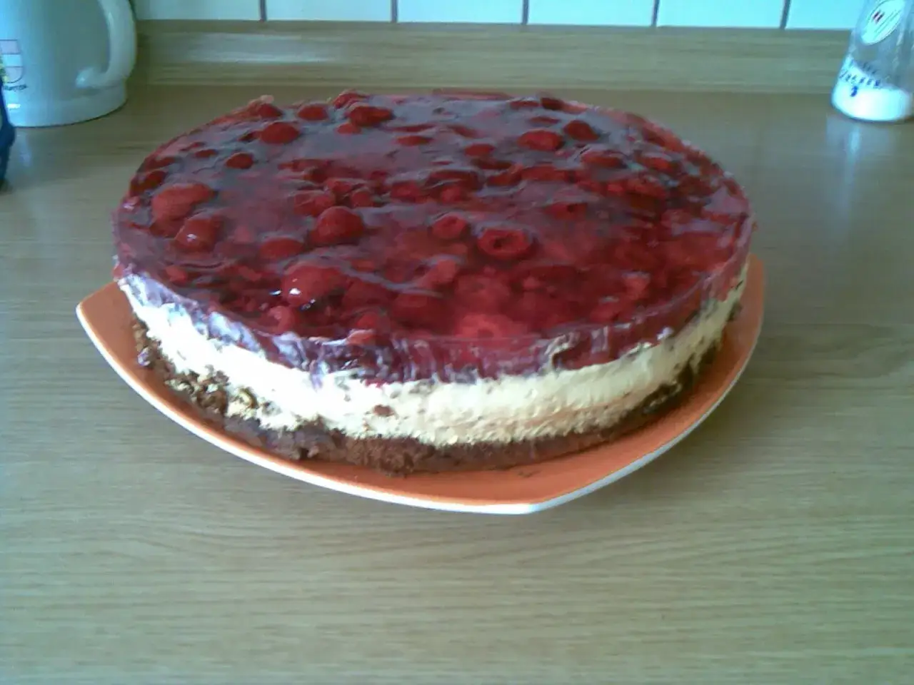 Eine köstliche Quark Sahne Torte mit fruchtigem Beeren-Gelee und einem Schokoladenboden.